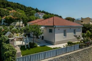 una casa blanca con techo rojo en una colina en Villa KaTess with heated pool, en Split
