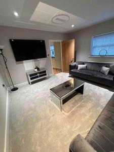 a living room with a couch and a flat screen tv at Cosy newly renovated 3 bedroom house - Town centre Horncastle in Lincolnshire