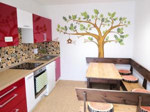 a kitchen with a table and a tree on the wall at Penzion Zelená zahrada in Kladenské Rovné