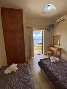 a bedroom with two beds and a view of the ocean at Vasiliki see view apartments in Barbati