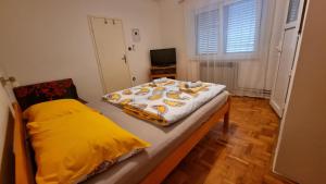 a bedroom with a bed with a yellow blanket on it at Guest House Jasmin in Rovinj