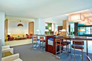 a kitchen and living room with a bar with stools at The Westin Wilmington in Wilmington