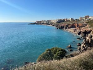 Una vista de una playa con gente en el agua. en Appartement 2 chambres en bord de mer 46m2, en Sète