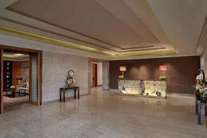 a lobby of a hotel with a fireplace and flowers at ITC Grand Chola, a Luxury Collection Hotel, Chennai in Chennai