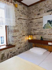 1 dormitorio con 2 camas y pared de piedra en Guest House and Hostel VAL-MAR, en Gjirokastra