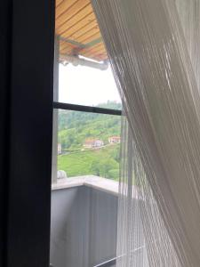 una ventana con vistas a una colina verde en Doğa içinde ferah huzurlu müstakil ev en Of