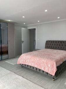 1 dormitorio con 1 cama grande con manta rosa en Doğa içinde ferah huzurlu müstakil ev en Of