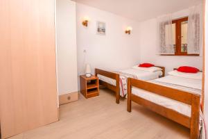 1 Schlafzimmer mit 2 Betten und einem Spiegel in der Unterkunft Apartments and Room Novokmet in Rogoznica