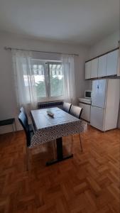 una camera con tavolo e una cucina con frigorifero di Guest House Jasmin a Rovigno (Rovinj)