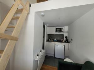 een kleine keuken met een trap in een kamer bij 2G- Studio tout équipé avec cuisine proche Paris in Issy-les-Moulineaux