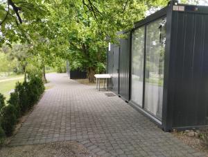 a bench on a sidewalk next to a black building at Šaltupio kaimo turizmas in Pakumprys