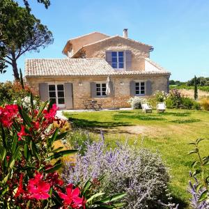 Le Cottage du Chat Blanc في Saint-Didier: منزل حجري قديم وامامه زهور