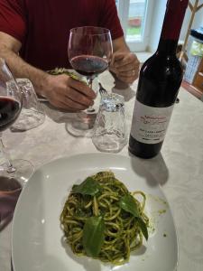 a plate of pasta and a bottle of wine at Agriturismo Rossolampone in Gerano