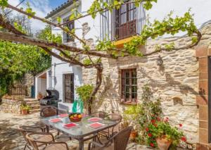 eine Terrasse mit Tisch und Stühlen vor einem Gebäude in der Unterkunft Molino del Caracol in Benaoján + 73 Fotos