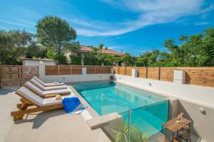 una piscina in un cortile con mobili da giardino e una piscina di Estella Luxury Villa in Amoudi -200m from the beach ad Amoudi