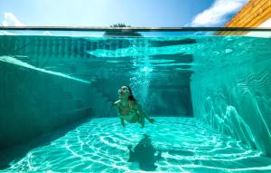 una donna in acqua in una piscina di Estella Luxury Villa in Amoudi -200m from the beach ad Amoudi