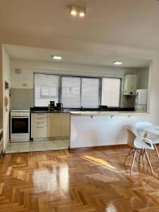 cocina grande con suelo de madera y electrodomésticos blancos en Hermoso departamento en Almagro en Buenos Aires