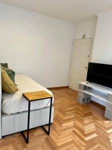 a room with a bed and a table and a television at Hermoso departamento en Almagro in Buenos Aires