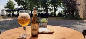 Eine Flasche Bier und ein Glas auf einem Tisch in der Unterkunft Varlet Farm in Poelkapelle