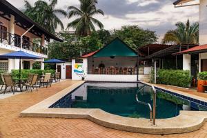- une piscine dans un complexe avec des tables et des chaises dans l'établissement Condiminium Villas Mymosa, à Manuel Antonio