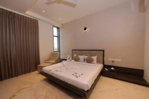 a bedroom with a large bed and a chair at VRR Astoria Hotel & Convention Center in Bangalore