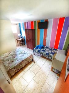 Zimmer mit einem Bett, einem Tisch und einem TV in der Unterkunft Pousada do Gil in Teresópolis