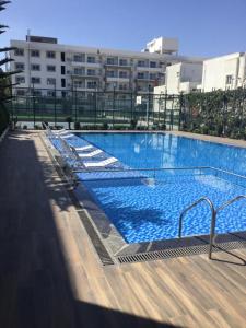 een groot zwembad met ligstoelen in een gebouw bij VRR Astoria Hotel & Convention Center in Bangalore
