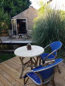 a table and chairs on a wooden deck with a table and chairs at La cabane de Mimi la Sardine in Saint-Gervais en-Belin