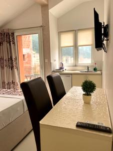 una habitación con mesa y sillas y un dormitorio en Pearl Apartments, en Budva