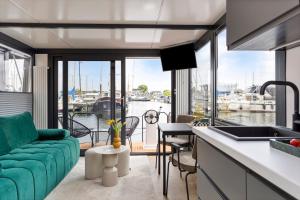 a kitchen and living room with a view of a marina at Cosy tiny houseboats near beach and restaurants in Zeewolde