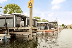 two boats are docked at a dock on the water at Cosy tiny houseboats near beach and restaurants in Zeewolde