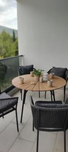 a wooden table and chairs on a balcony at Avisi Living in Trebinje