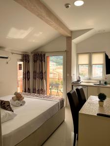 Pearl Apartments في بودفا: غرفة نوم بسرير وطاولة ونافذة