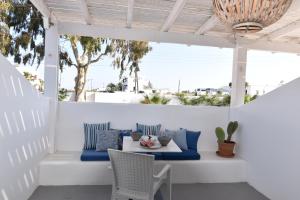 a white porch with a table and chairs at Aegeeis in Perissa