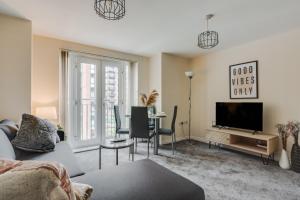a living room with a couch and a tv at Stylish 2 Bed Manchester Flat in Manchester