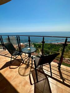 Arcadia apartment & sea terrace في أوديسا: شرفة مع طاولة وكراسي والمحيط