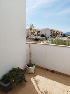 una pared blanca con una maceta en un patio en Villa de lujo frente al mar, en Barrio-Mar