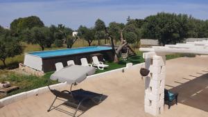eine Terrasse mit 2 Stühlen und einem Pool in der Unterkunft Trullo Titti in Ostuni