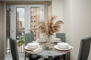 a dining room with a table and chairs and a window at Stylish 2 Bed Manchester Flat in Manchester