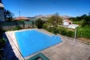 een groot blauw zwembad in een achtertuin bij Casa do Destro in Ponte da Barca