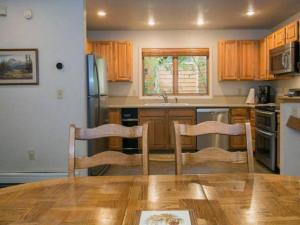 - une cuisine avec des placards en bois, une table et des chaises dans l'établissement 3-bedroom Condo near Lake,Hyatt,Diamond Peak, à Incline Village