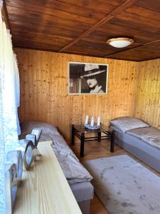 Habitación con 2 camas en una habitación de madera en Chata U Řeky, 