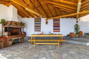eine Terrasse mit einem Holztisch und einem Kamin in der Unterkunft Remezzo Cottage in Skopelos + 23 Fotos