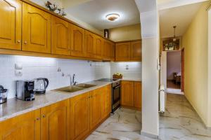 a kitchen with wooden cabinets and a sink at Remezzo Cottage in Skopelos Town +19 photos