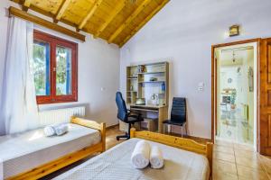 ein Schlafzimmer mit zwei Betten und einem Schreibtisch und einem Stuhl in der Unterkunft Remezzo Cottage in Skopelos
