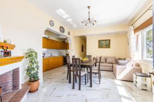 a kitchen and living room with a table and chairs at Remezzo Cottage in Skopelos Town