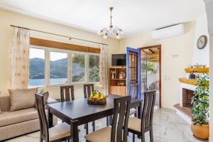 a dining room and living room with a table and chairs at Remezzo Cottage in Skopelos Town