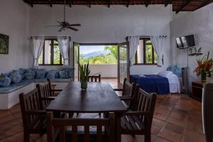 una sala da pranzo con tavolo, sedie e divano di Condiminium Villas Mymosa a Manuel Antonio