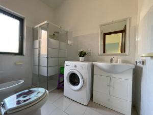 a bathroom with a washing machine and a sink at Appartamenti magnolie-La pineta in Valledoria