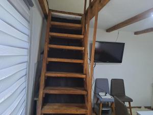 a wooden staircase in a room with a tv and chairs at Natural House in Visoko